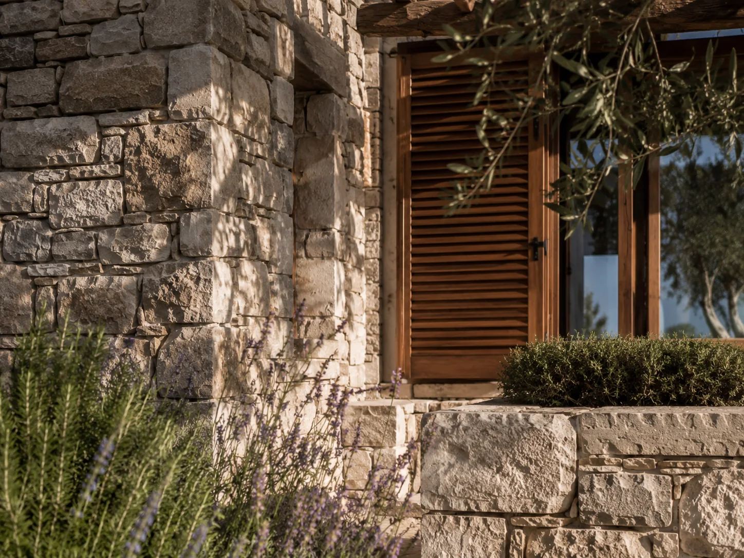 Detailaufnahme einer gepflegten Natursteinfassade mit Holzfensterläden